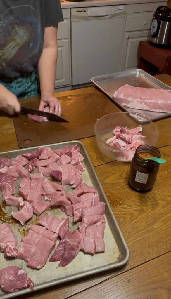 lady cutting pork loin on cutting board 